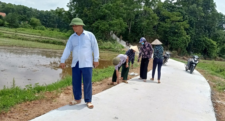 Ông Vũ Văn Cam (áo trắng) xuyên vận động nhân dân tham gia dọn dẹp vệ sinh những con đường bê tông mới hoàn thiện trên địa bàn thôn.