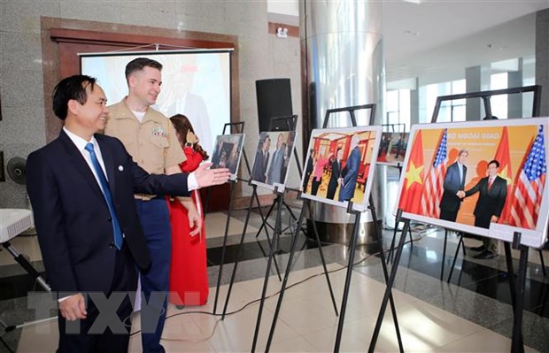 Thiếu tá Chuck Casey, Tùy viên Thủy quân Lục chiến Hoa Kỳ tại Việt Nam và ông Võ Văn Hưng, Chủ tịch UBND tỉnh Quảng Trị xem triển lãm. (Ảnh: Hồ Cầu/TTXVN)