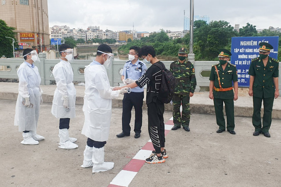 Lực lượng chức năng làm thủ tục trao trả 5 công dân Trung Quốc về nước qua Cửa khẩu Quốc tế Móng Cái.