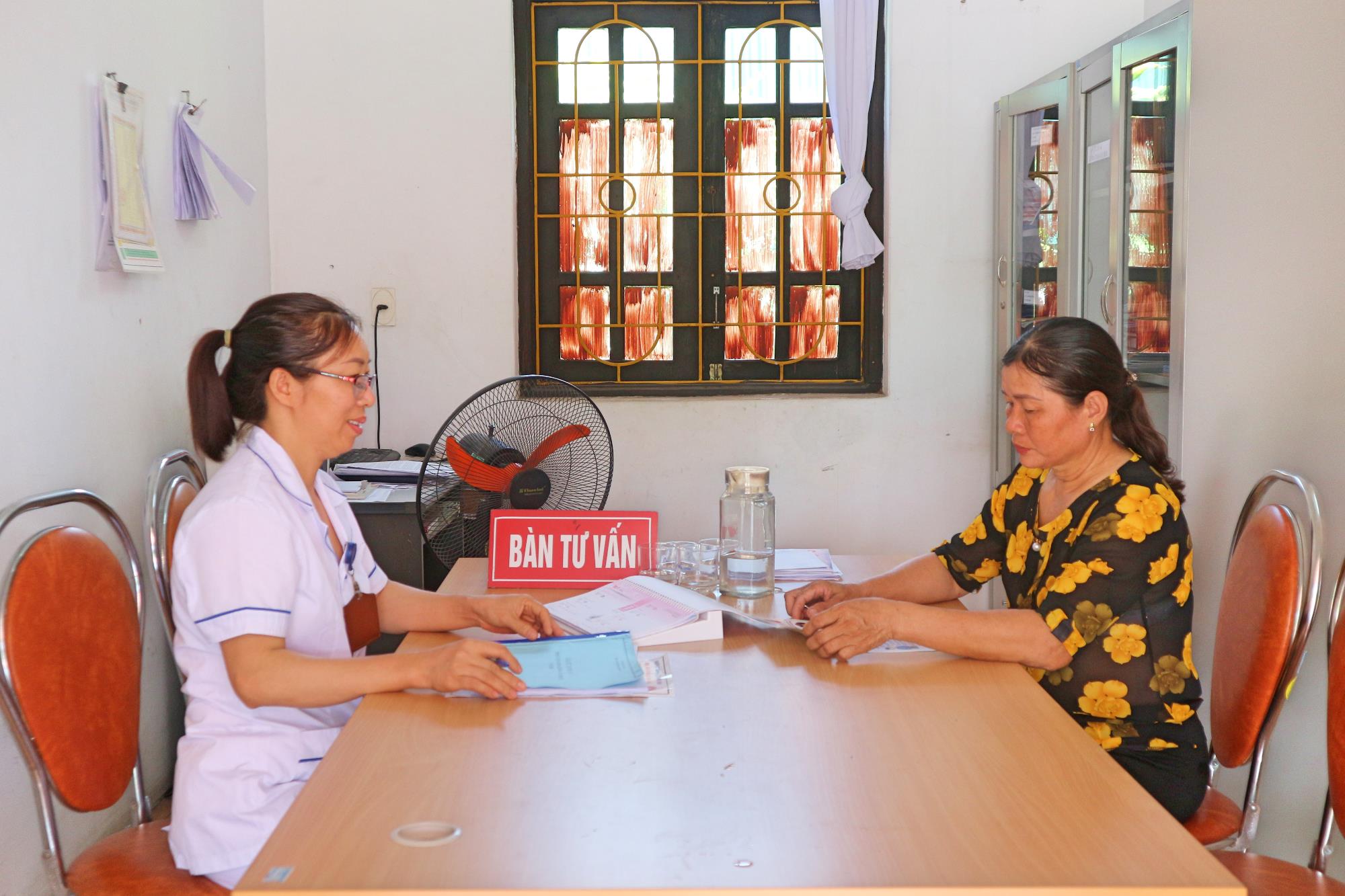 Cộng tác viên dân số khu Yên Sinh đang trao đổi với cán bộ y tế phường Tràng An về công tác lập sổ theo dõi các đối tượng có nguy cơ cao trên địa bàn
