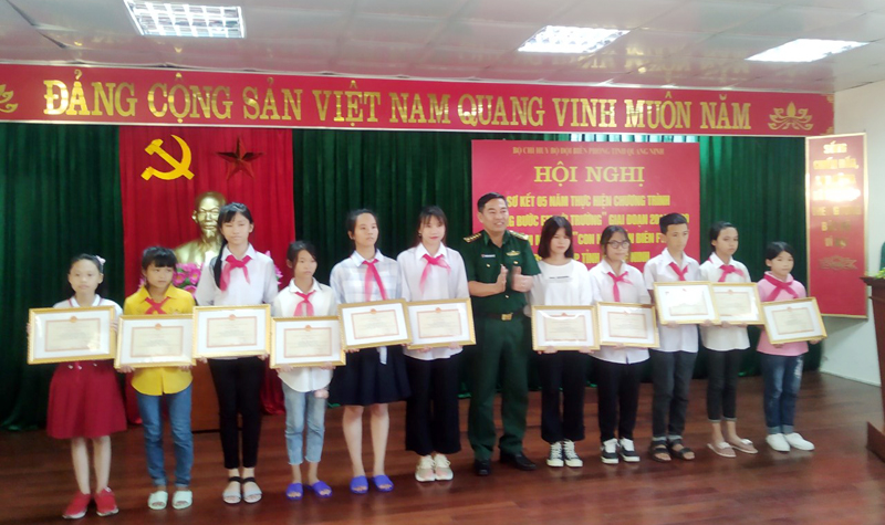 Đại tá Nguyễn Thanh Hải, Chính ủy BĐBP tỉnh khen thưởng cho các cháu học sinh có thành tích cao trong học tập.