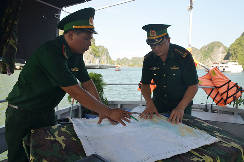 Thiếu tá Trần Tiến Đạt (trái) trao đổi phương án tuần tra với cán bộ của đơn vị.
