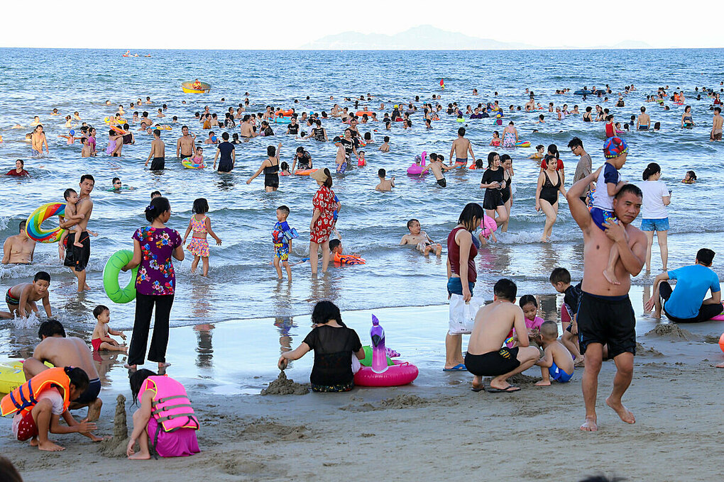 Bãi biển Mỹ Khê, Đà Nẵng ngày 25/7 đông đúc du khách. Dịp cuối tuần, Mỹ Khê thường có 30.000 đến 40.000 khách tắm biển. Cùng ngày 25/7, ca Covid-19 đầu tiên được phát hiện trong cộng đồng sau 99 ngày ở thành phố biển này. Ảnh: Nguyễn Đông.