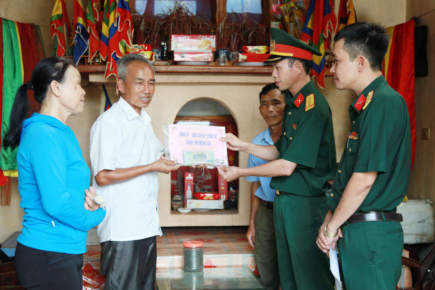 Thượng tá Mai Xuân Thắng, Chính trị viên Ban CHQS TP Móng Cái  trao số tiền 80 triệu đồng cho gia đình ông Phạm Văn Đế.