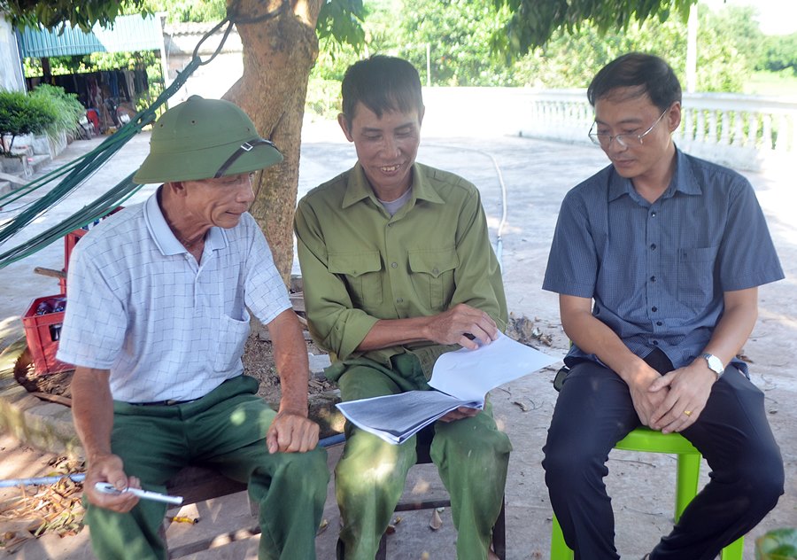 CCB Trần Văn Thành (ngồi giữa) cùng lãnh đạo xã Dực Yên và Hội CCB xã xem nội dung quy định mức đền bù.