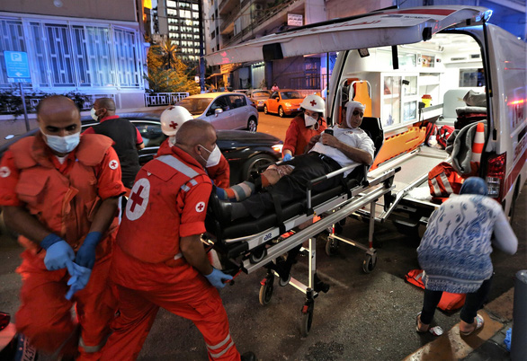 Nhân viên y tế chuyển một nạn nhân từ một bệnh viện này sang một bệnh viện khác ở Beirut ngày 4-8 - Ảnh: EPA