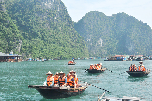 Du khách quốc tế sử dụng dịch vụ thuyền nan tham quan làng chài Cửa Vạn trên Vịnh Hạ Long. Ảnh: Đại Dương