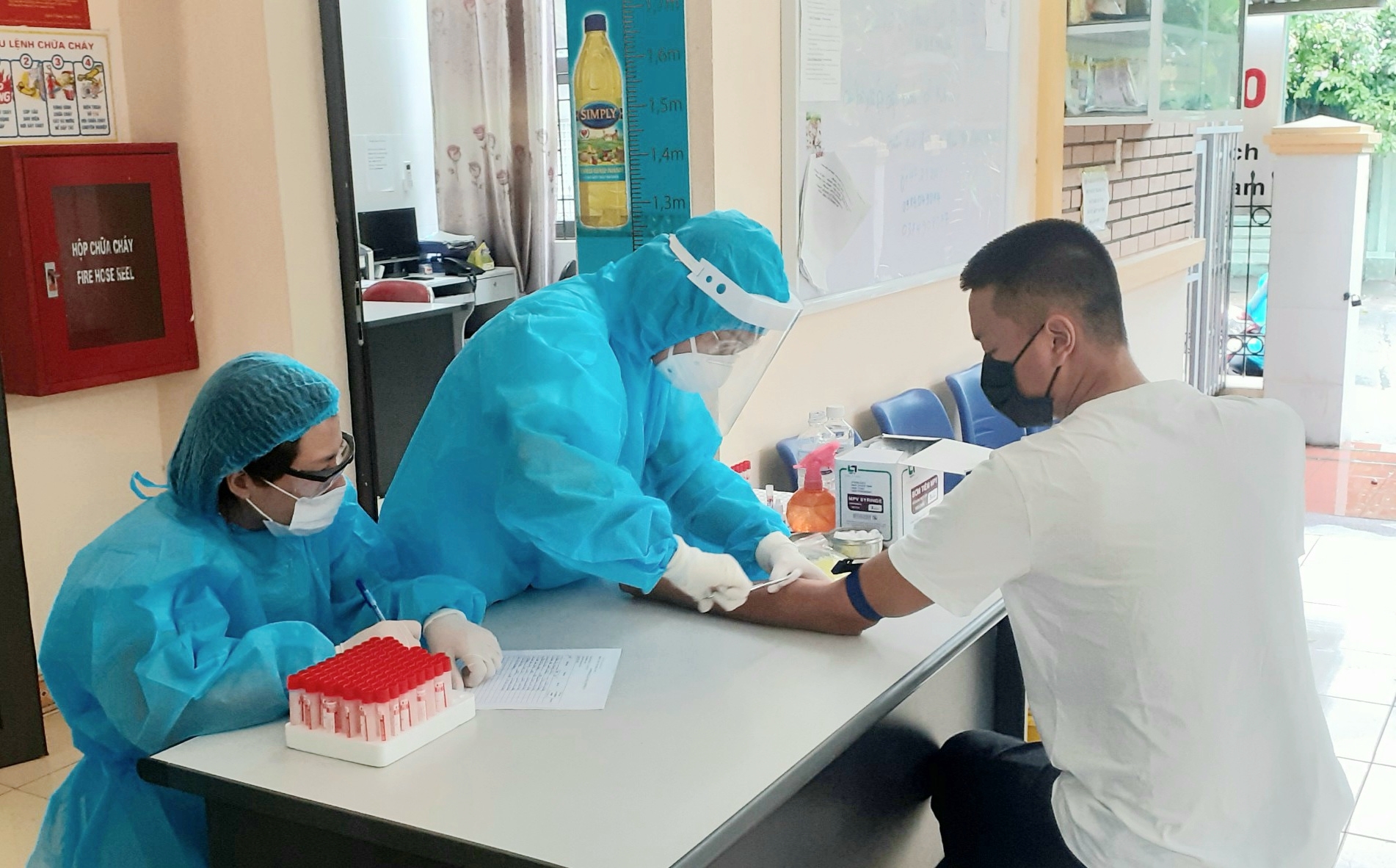  Cán bộ y tế TTYT TP Hạ Long lấy máu xét nghiệm nhanh virus SARS-CoV-2 đối với người từ Đà Nẵng trở về.