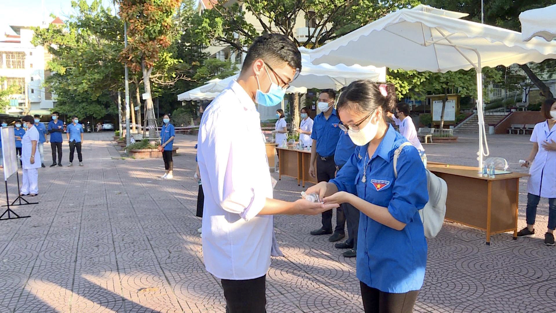 ĐVTN hỗ trợ thí sinh sát khuẩn tay trước khi vào khu vực thi tại điểm thi trưởng THPT Hòn Gai, TP Hạ Long