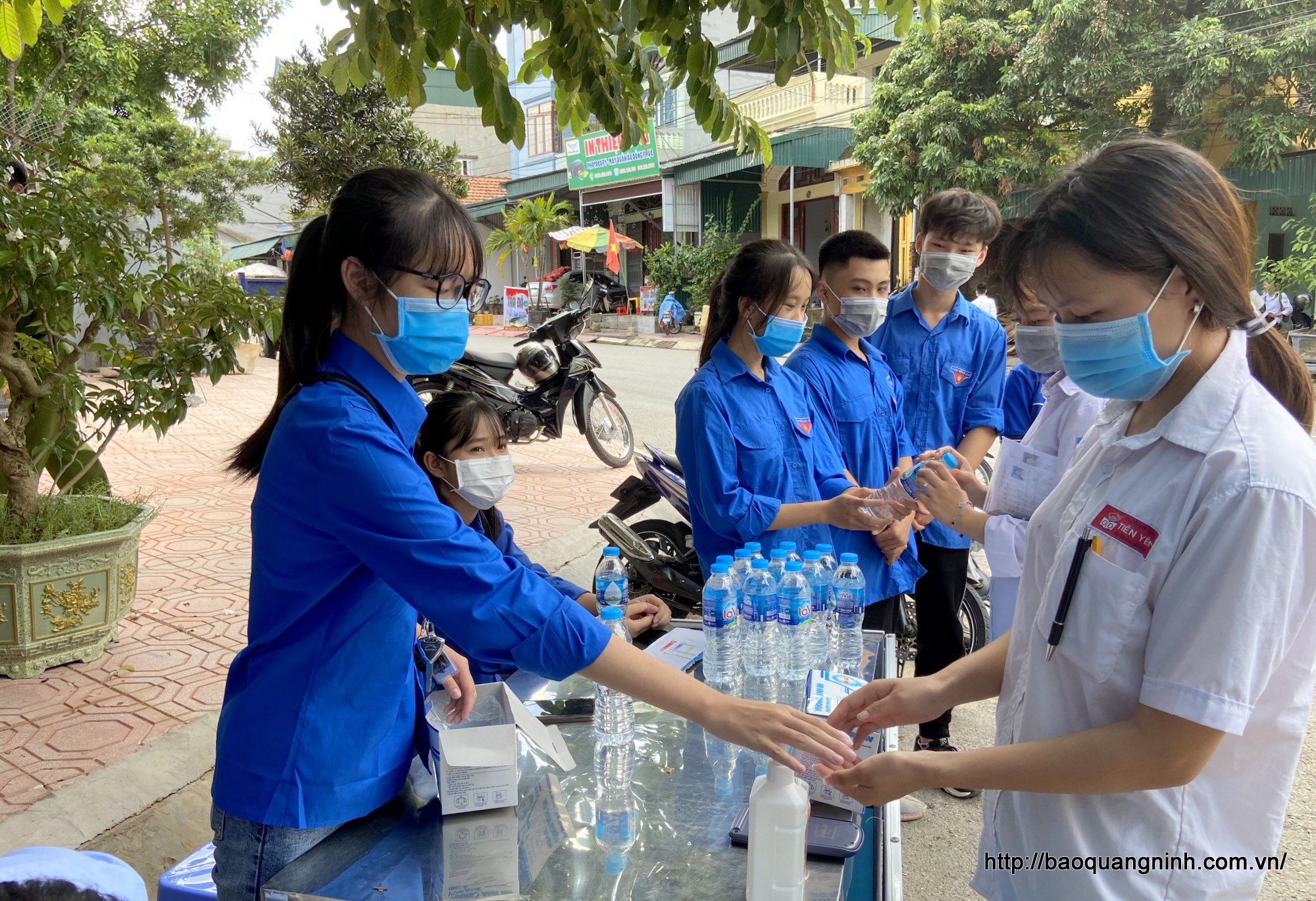 Thanh niên tình nguyện hướng dẫn thí sinh rửa tay bằng dung dịch sát khuẩn trước khi vào khu vực thi.