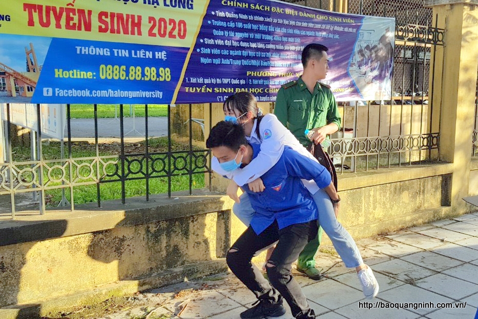 Một thanh niên tình nguyện cõng thí sinh bị đau chân, không thể tự đi đên phòng thi tại Điểm thi THPT Tiên Yên.