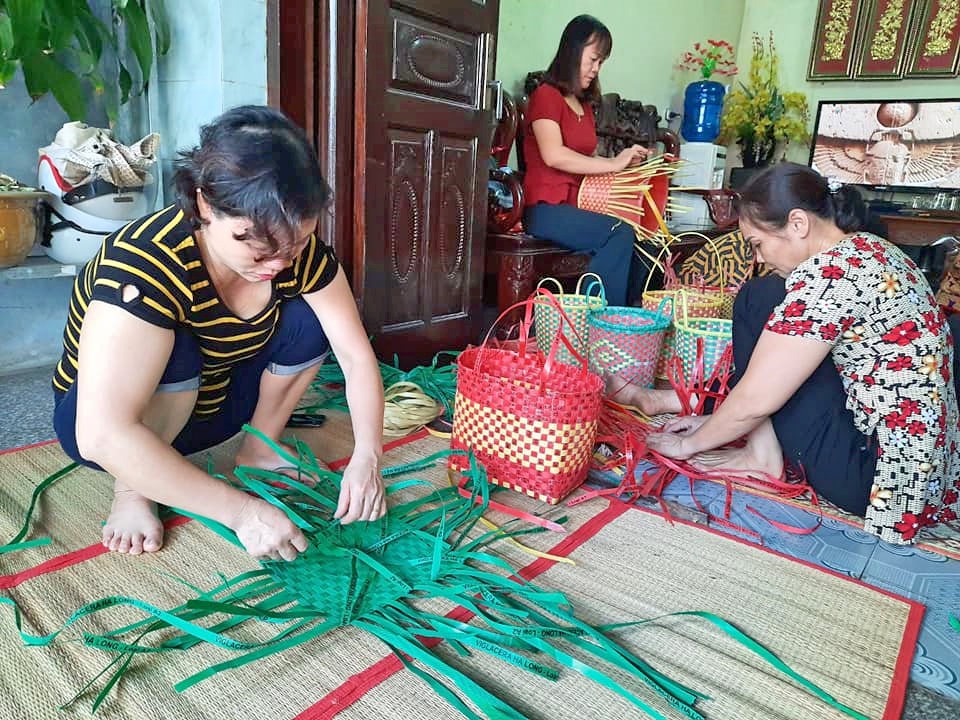 Phụ nữ phường Hà Trung tham gia đan làn từ những dây buộc gạch tái chế.