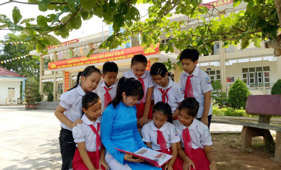 Cô và trò Trường Tiểu học Quảng Tân (xã Quảng Tân, huyện Đầm Hà), đọc sách ngoài sân trường.