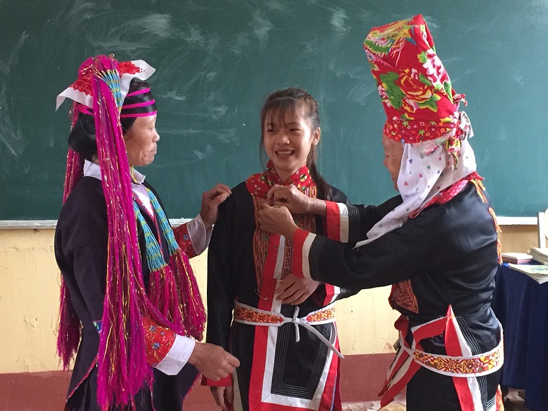 Nghệ nhân Giềng Chống Sếnh xã Quảng Sơn dạy các em học sinh cách mặc bộ sắc phục của người Dao Thanh Y