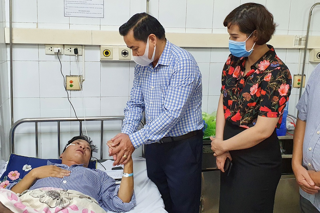 Đồng chí Hoàng Đức Hạnh, Phó Chủ tịch Ủy ban MTTQ tỉnh (trái) thăm hỏi nạn nhân đang điều trị tại Bệnh viên Đa khoa tỉnh.