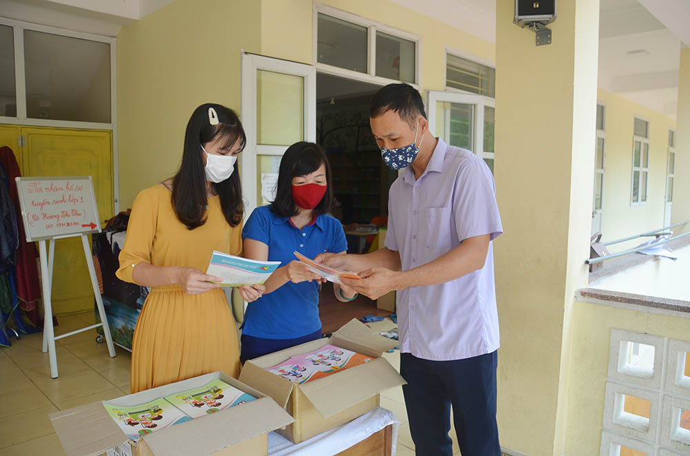 Giáo viên Trường Tiểu học thị trấn Ba Chẽ, huyện Ba Chẽ, phát sách giáo khoa lớp 1 cho phụ huynh học sinh.