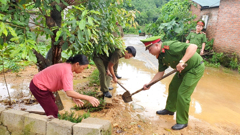 Công an xã Quảng Đức (huyện Hải Hà) giúp dân khơi thông điểm ngập, lầy lội dẫn vào nhà.