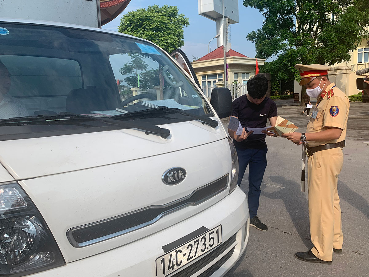 Cán bộ Đội CSGT Công an TX Đông Triều đang kiểm tra hành chính người điều khiển phương tiện tham gia giao thông trên địa địa bàn. 
