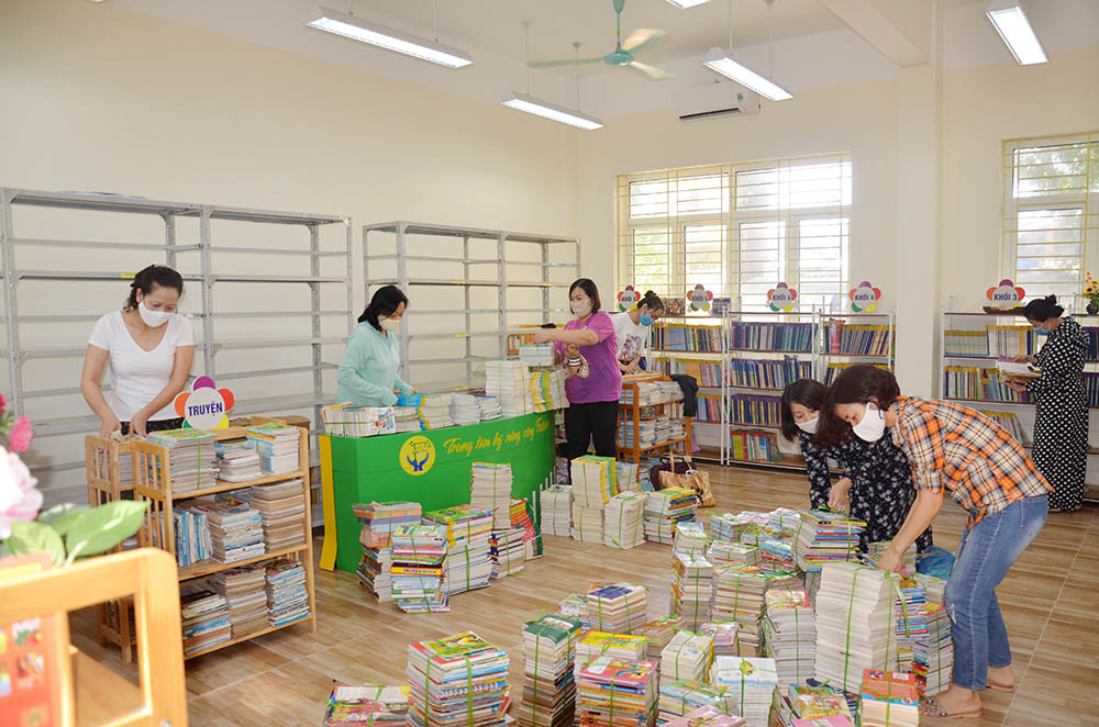 Giáo viên Trường Tiểu học Trần Hưng Đạo, TP Hạ Long sắp xếp lại sách trong phòng thư viện, chuẩn bị cho năm học mới.