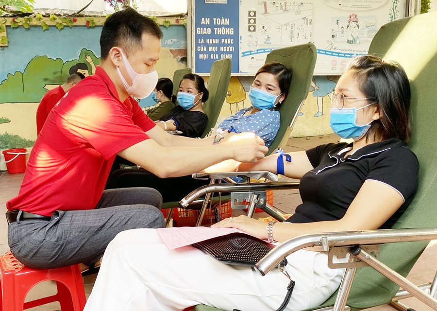 Tình nguyện viên CTĐ huyện Vân Đồn hỗ trợ người dân tham gia hiến máu tình nguyện.
