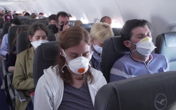 Hành khách đi máy bay phải đeo khẩu trang trong mùa dịch Covid-19. Ảnh: CNN.