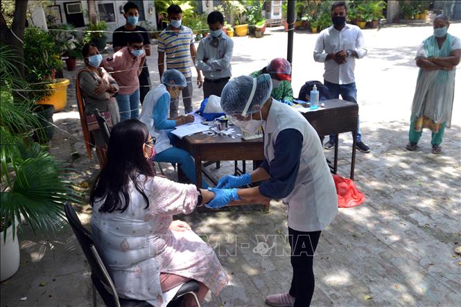 Nhân viên y tế lấy mẫu xét nghiệm COVID-19 cho người dân tại New Delhi, Ấn Độ. Ảnh: THX/TTXVN