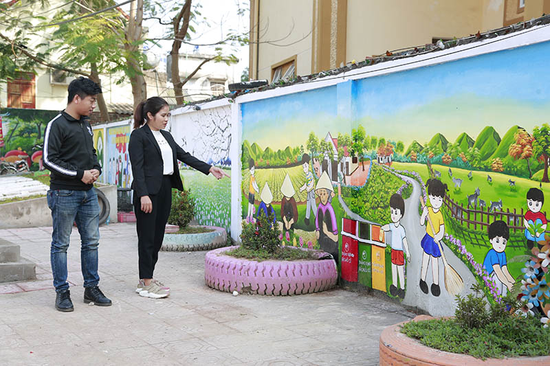 Bí thư Chi bộ, Trưởng thôn Làng Nhội Nguyễn Ái Việt giới thiệu những bức tranh tường do chị vẽ.