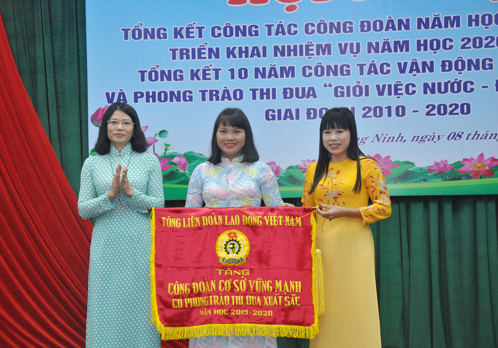 Phó Chủ tịch Thường trực LĐLĐ tỉnh Đỗ Thị Ninh Hường trao tặng cờ của Tổng LĐLĐ Việt Nam cho Công đoàn trường THPT Nguyễn Bình.