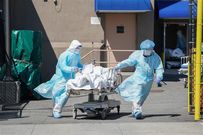 Chuyển bệnh nhân tử vong do COVID-19 tới nhà xác tại bệnh viện ở Brooklyn, New York, Mỹ. Ảnh: AFP/TTXVN