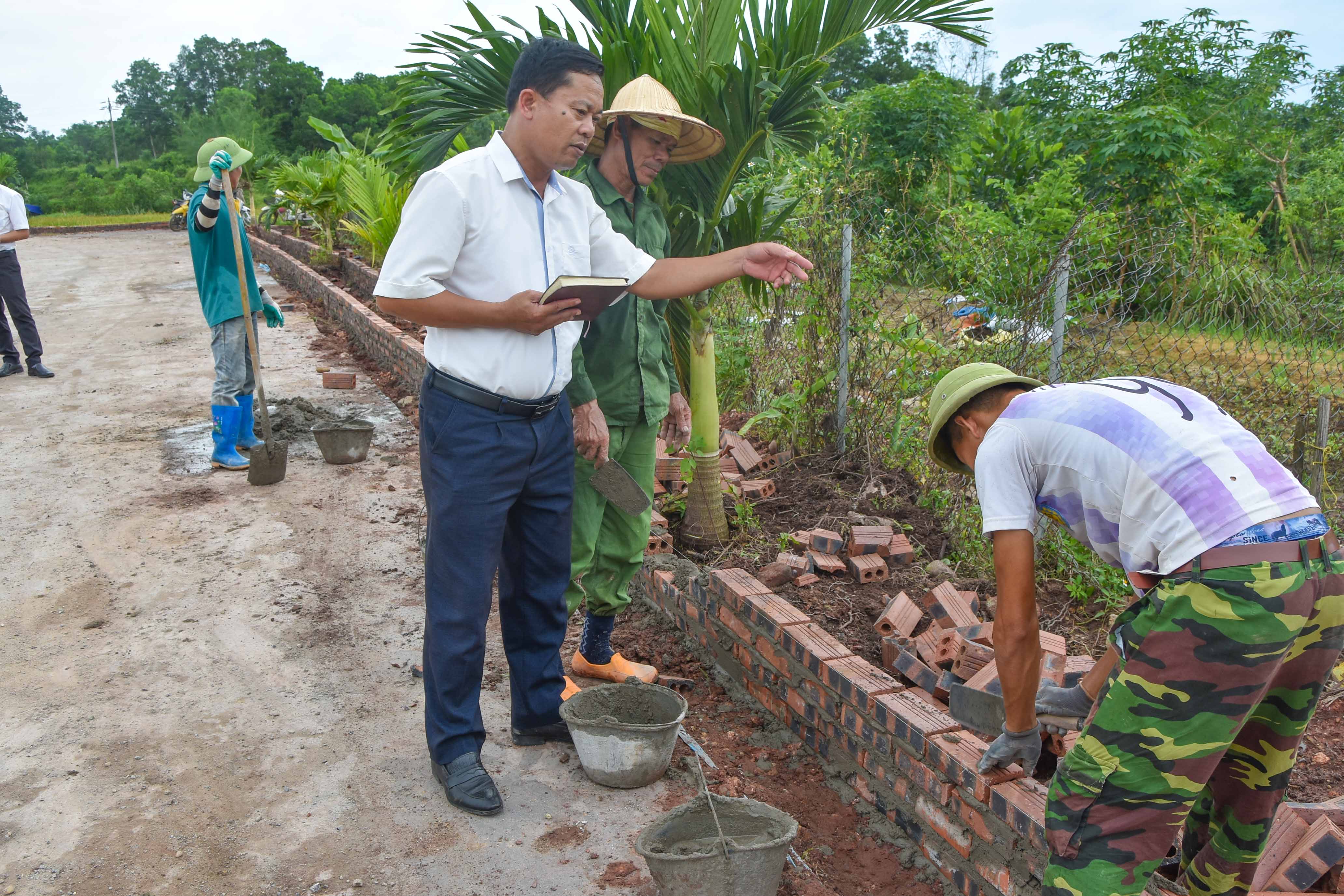 Cán bộ xã Quảng Tân (huyện Đầm Hà) kiểm tra tiến độ thi công cải tạo tuyến đường hoa, tạo cảnh quan nông thôn mới.