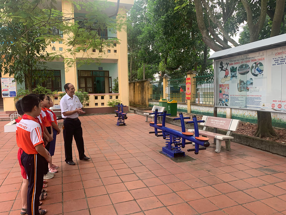 Các em học sinh Trường Tiểu học Lý Thường Kiệt, TP Uông Bí đang nghe các CCB truyên truyền Luật Giao thông. 
