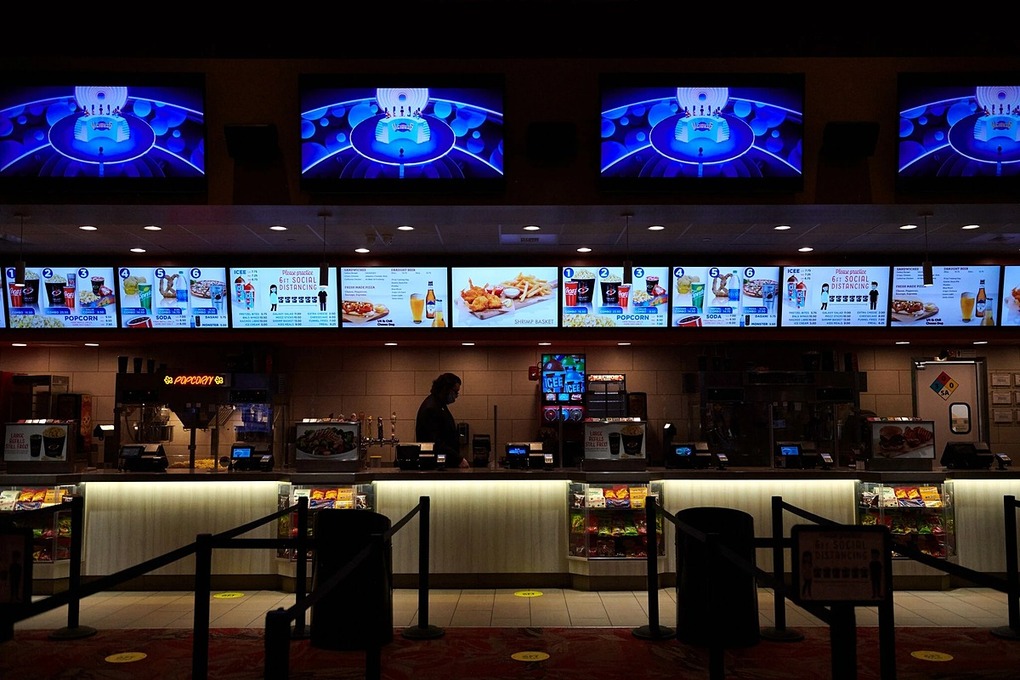 Khu vực bán đồ ăn vắng người trong một rạp phim đã mở lại ở Mỹ. Ảnh: NYT