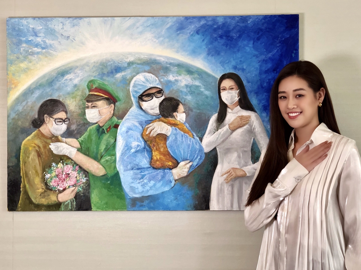 Hoa hậu Khánh Vân bên bức tranh “Những trái tim dũng cảm”.