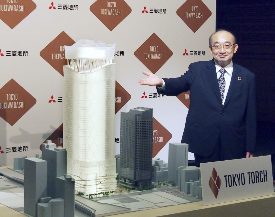 Chủ tịch công ty bất động sản Mitsubishi Junichi Yoshida bên mô hình tòa tháp cao nhất Nhật Bản, Torch Tower, tại họp báo ngày 17/9. Ảnh: Kyodo.