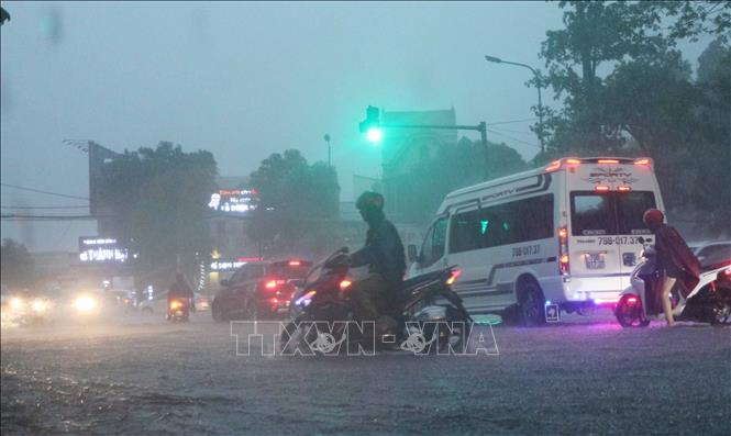 Các phương tiện tham gia giao thông gặp khó khăn do mưa lớn. Ảnh: Nguyễn Oanh/TTXVN.