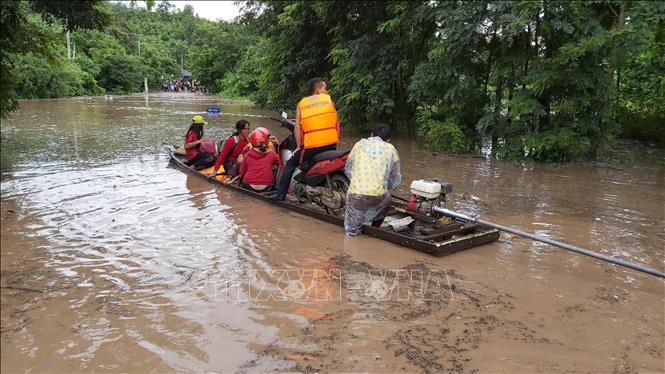 Lực lượng công an, quân đội giúp nhân dân qua lại bằng đò để bảo đảm giao thông trên tuyến đường Lìa, huyện Hướng Hóa (Quảng Trị) bị ngập lụt. Ảnh: Nguyên Lý/TTXVN