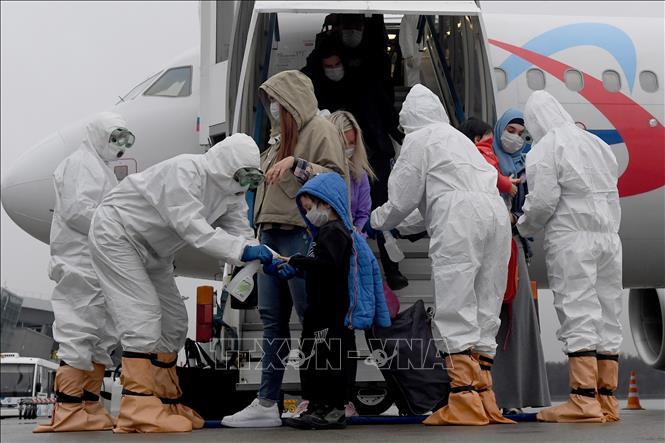 Nhân viên y tế phun thuốc khử trùng cho hành khách nhằm ngừa dịch COVID-19 tại sân bay Kazan, Nga. Ảnh: Xinhua/TTXVN