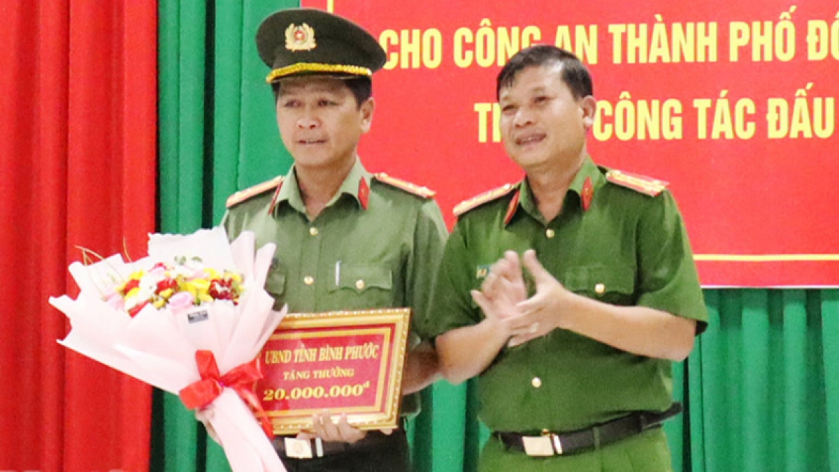 Thừa ủy nhiệm của UBND tỉnh, lãnh đạo Công an tỉnh Bình Phước trao tiền thưởng cho Công an thành phố Đồng Xoài (Ảnh: Báo Bình Phước)