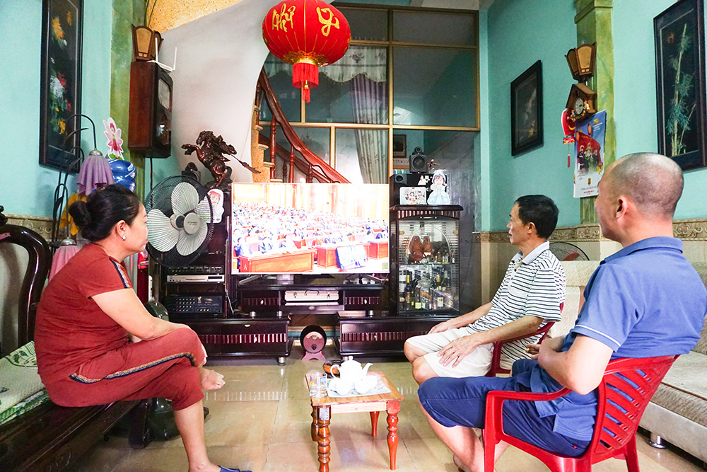 Người dân khu phố Phan Đình Phùng, phường Cẩm Tây, TP Cẩm Phả chăm chú theo dõi Đại hội Đảng bộ tỉnh. 
