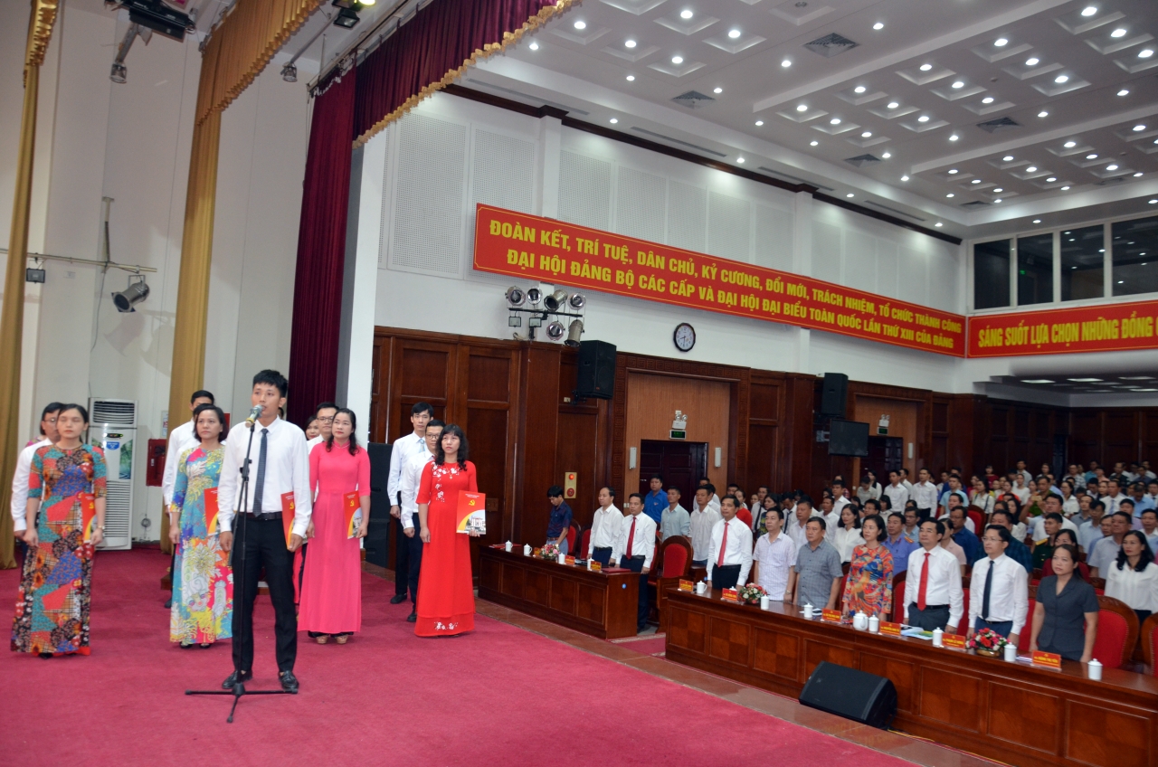Các Đảng viên tuyên thệ dưới  cờ Đảng và chân dung Chủ tịch Hồ Chí Minh