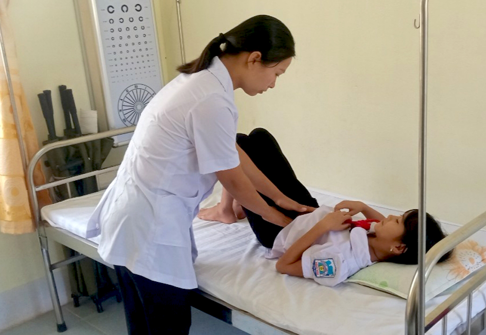 Nhân viên y tế Trường Phổ thông Dân tộc bán trú tiểu học và THCS Đồng Văn (Bình Liêu) kiểm tra sức khỏe ban đầu cho học sinh của trường bị đau bụng.