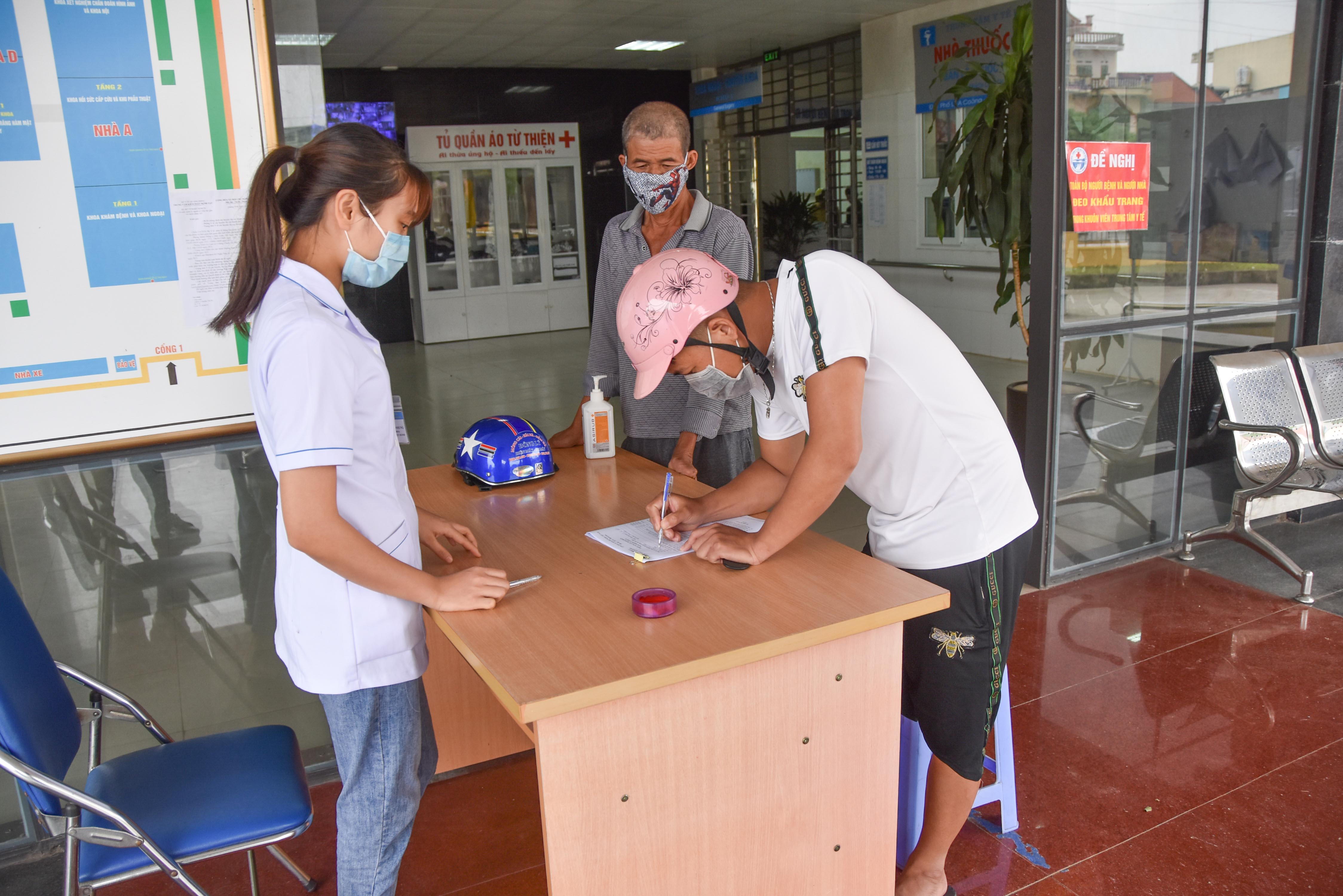 Người dân khai báo y tế tại Trung tâm Y tế huyện Đầm Hà, chấp hành nghiêm quy định phòng, chống dịch Covid-19.