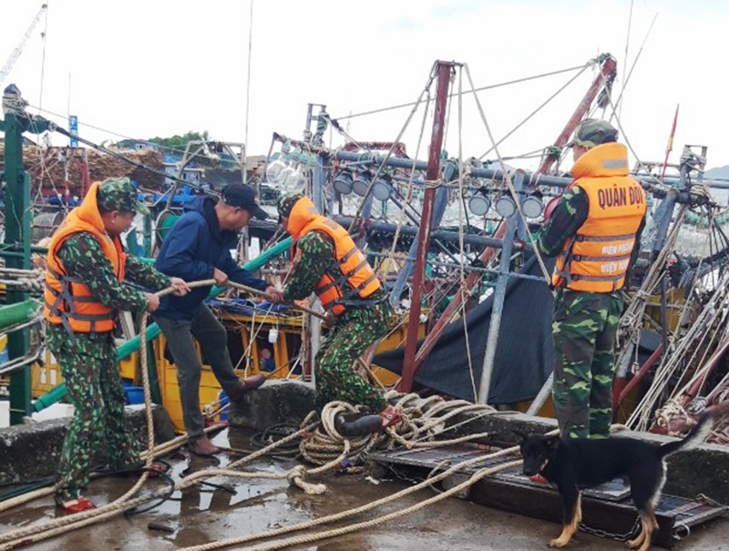 Cán bộ, chiến sỹ Đồn BP Quảng Đức giúp ngư dân huyện Hải Hà gia cố, chằng buộc tàu thuyền tránh trú bão.