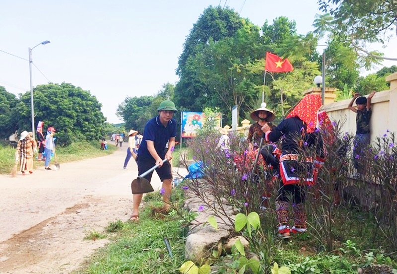 Cán bộ, người dân xã Qảng Sơn tham gia dọn vệ sinh môi trường.