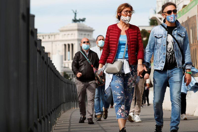 Người dân đeo khẩu trang khi ra đường ở Rome, Italy. Ảnh: Reuters