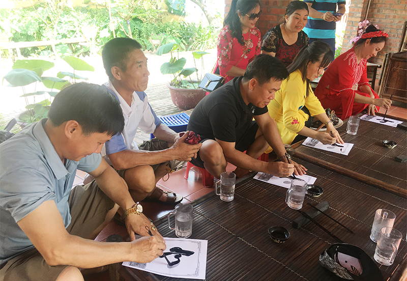 Du khách trải nghiệm viết thư pháp tại Khu du lịch Quảng Ninh gate.