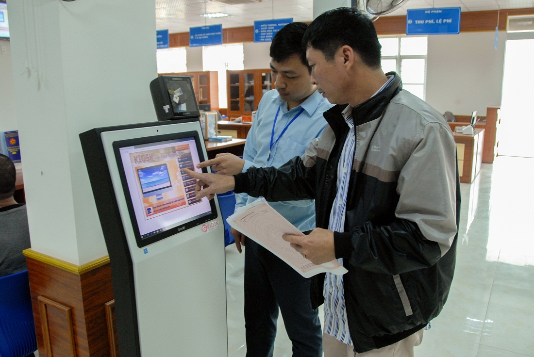 Cán bộ Trung tâm Hành chính công huyện Đầm Hà hướng dẫn công dân tra cứu thông tin trên ki ốt điện tử.