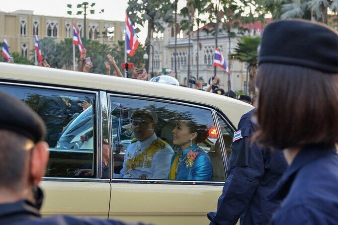 Hoàng hậu Suthida và Hoàng tử Dipangkorn Rasmijoti trên xe limousine đi qua đám đông biểu tình ở Bangkok chiều 14/10. Ảnh: AFP.