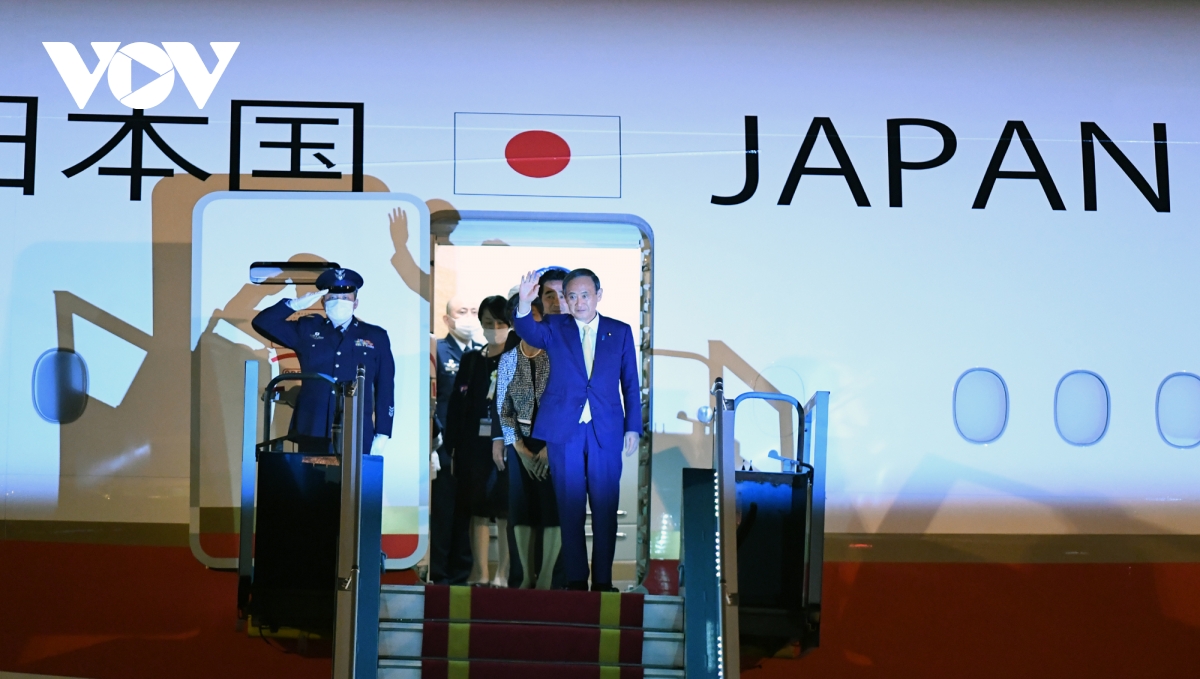 Thủ tướng Nhật Bản Suga Yoshihide và Phu nhân xuất hiện tại cửa máy bay, vẫy chào những người ra đón ông.