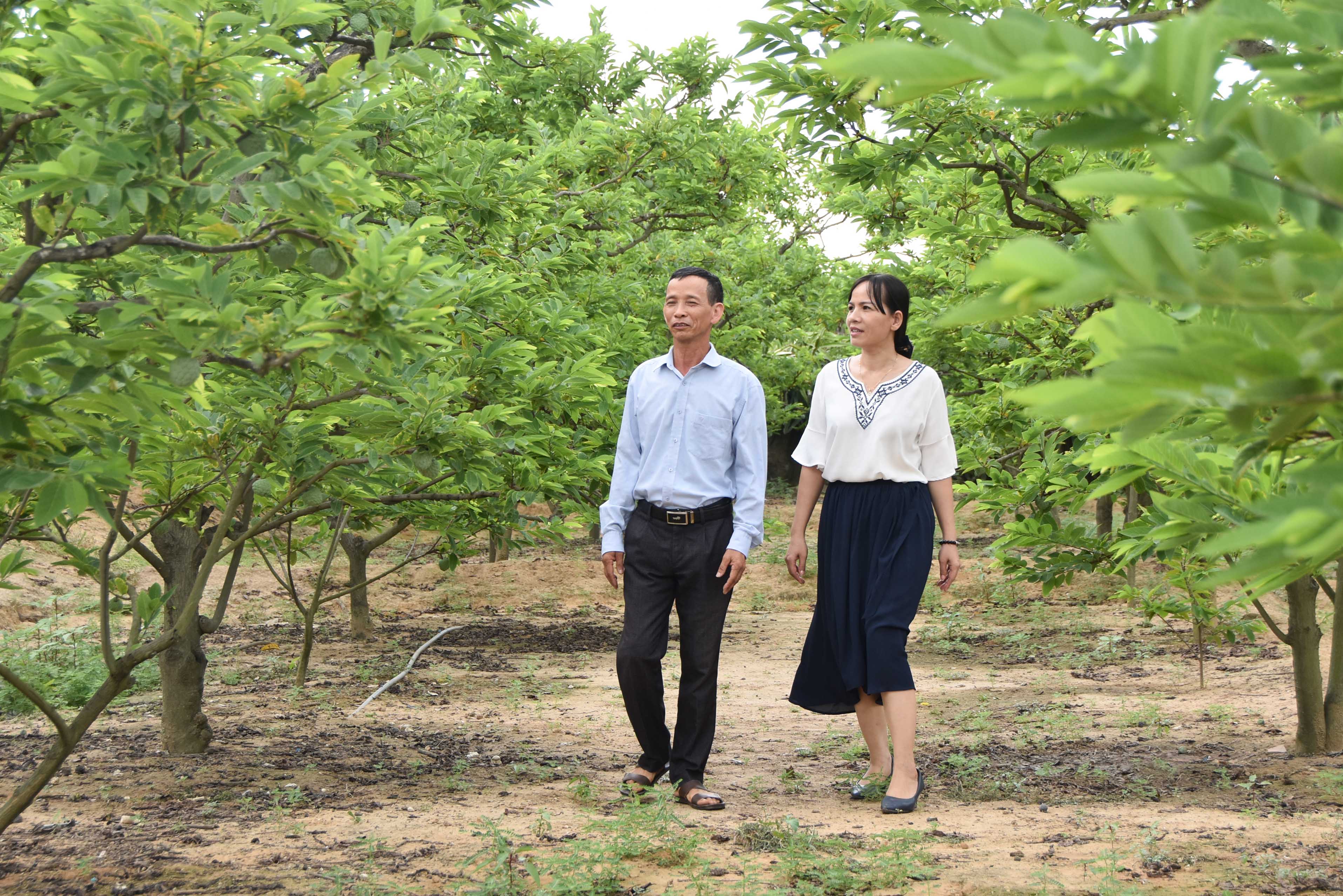 Cán bộ MTTQ TX Đông Triều (phải) nắm tình hình phát triển vườn mẫu, thi đua xây dựng nông thôn mới tại xã Việt Dân.